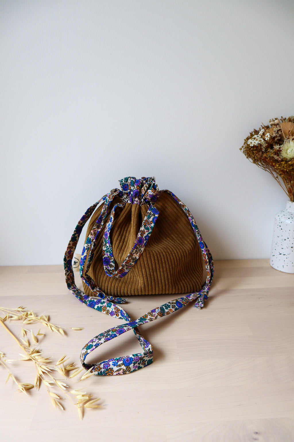 Petit sac bourse fermé en velours côtelé marron, avec bandoulière et anses à fleurs bleues et violettes