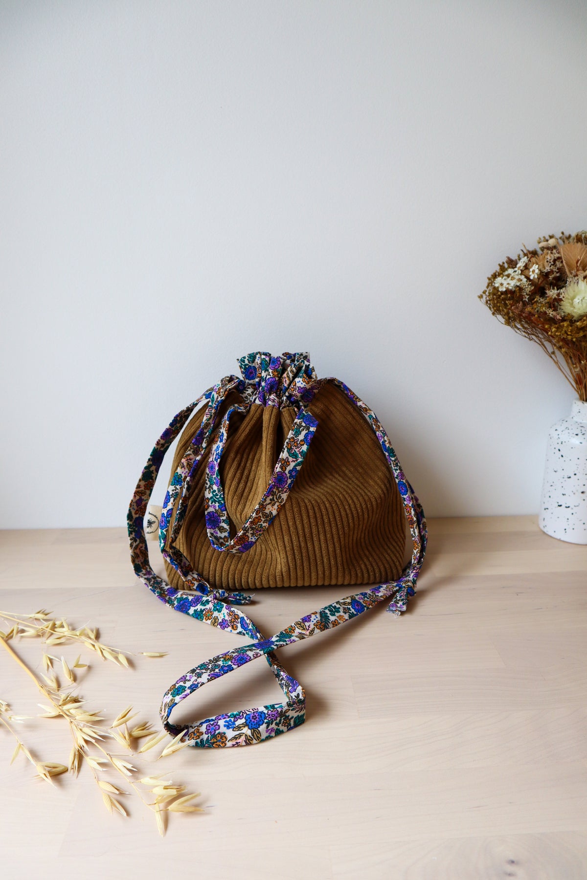 Petit sac bourse fermé en velours côtelé marron, avec bandoulière et anses à fleurs bleues et violettes